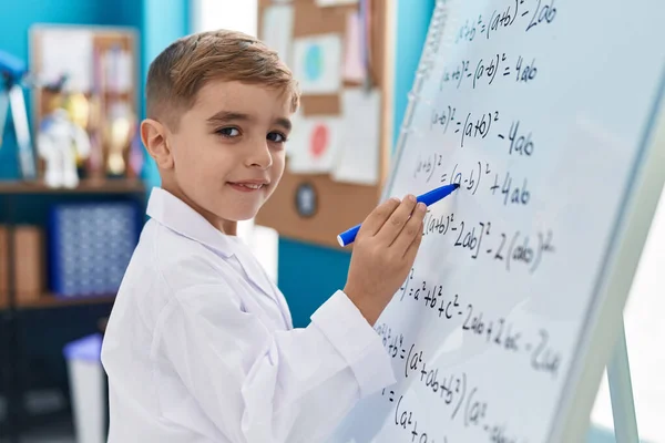 在实验室的磁板上教数学的他那可敬的惊慌男孩 — 图库照片