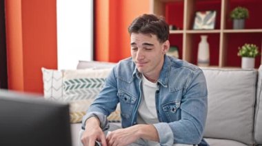 Genç İspanyol adam evde ağlarken kanepeye oturup hüzünlü bir film izliyor.
