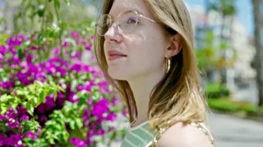 Parkta alerji yüzünden hapşıran genç sarışın kadın.