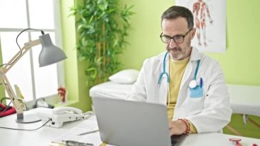 Klinikte telefonla konuşan orta yaşlı bir doktor.