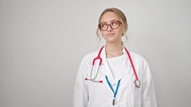 年轻的金发女医生带着自信的笑容 呈现在孤独的白人背景上 — 图库视频影像
