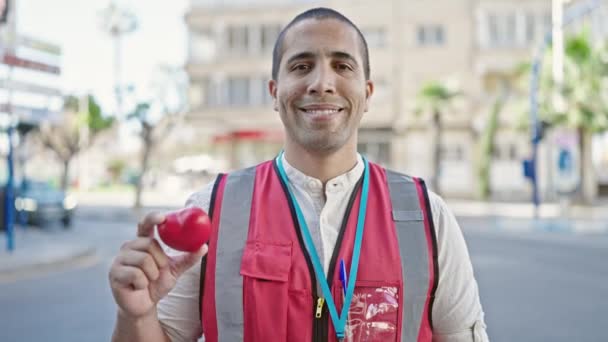 Giovane Uomo Ispanico Volontario Sorridente Possesso Cuore Rosso Donazione Sangue — Video Stock