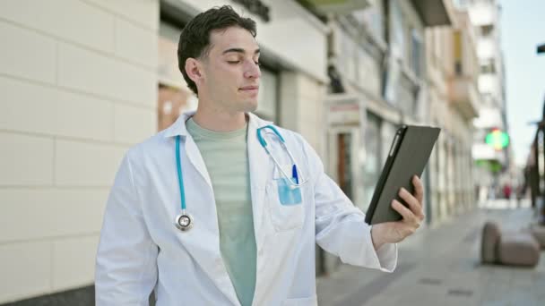 Jovem Hispânico Homem Médico Fazendo Videochamada Com Touchpad Hospital — Vídeo de Stock