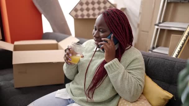 Afrikansk Kvinna Med Flätat Hår Ler Tryggt Talar Smartphone Nytt — Stockvideo