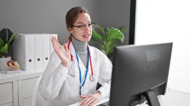 Genç beyaz kadın doktor, klinikte video görüşmesi olduğunu vurguladı.