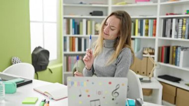 Kütüphane üniversitesinde baterist olarak kalem kullanan beyaz bir kız öğrenci.
