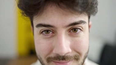 Evdeki kanepede kendinden emin gülümseyen İspanyol genç adam.