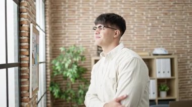 Genç İspanyol iş adamı ofiste kendinden emin gülümsüyor.