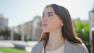 Ciddi bir ifadeyle genç İspanyol kadın parktaki kameraya bakıyor.