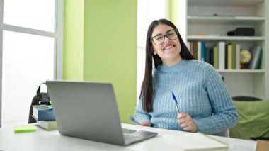 Genç İspanyol öğrenci kütüphanede baterist olarak kalem kullanıyor.