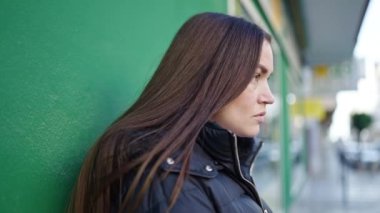 Young caucasian woman standing with serious expression at street