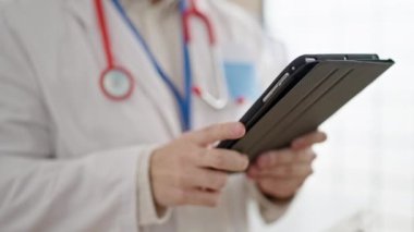 Genç İspanyol doktor klinikte dokunmatik ped kullanıyor.