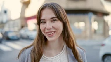 Sokakta kendinden emin gülümseyen genç İspanyol kadın.