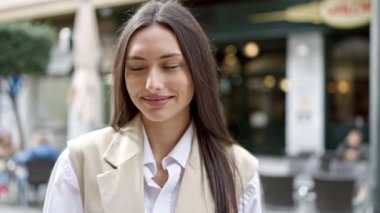 Genç, güzel, İspanyol bir kadın gülümsüyor. Kendine güveniyor.