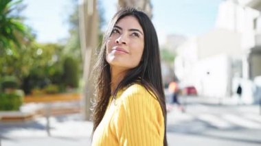 Young beautiful hispanic woman smiling confident looking to the sky at park