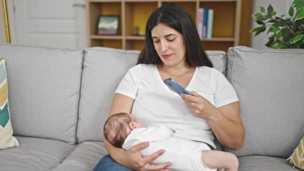Mère Fille Bébé Assis Sur Canapé Tenant Bébé Utilisant Smartphone — Video