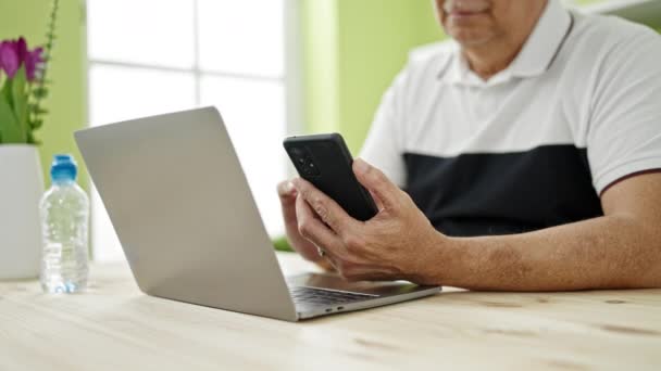 Homem Meia Idade Com Cabelos Grisalhos Usando Smartphone Laptop Sala — Vídeo de Stock