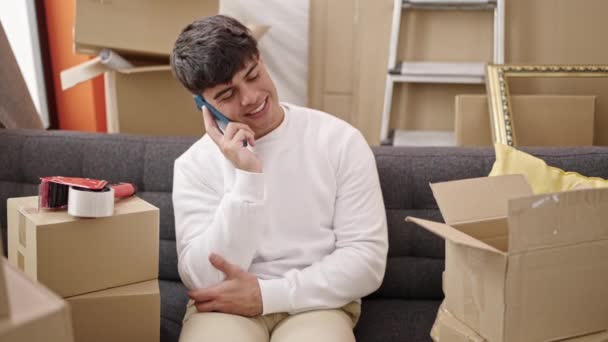 Ung Latinamerikansk Man Talar Smartphone Sitter Soffan Nytt Hem — Stockvideo