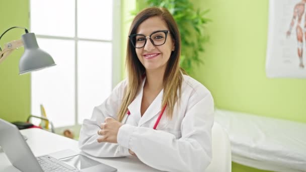 中東の女性医師は 診療所で眼鏡を外すノートパソコンを使用しています — ストック動画