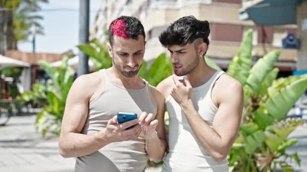 Zwei Männer Nutzen Smartphone Mit Zweifelhaftem Gesichtsausdruck Park — Stockvideo