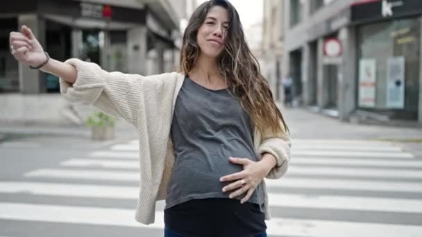 Молодая Беременная Женщина Улыбается Уверенно Делая Сильный Жест Рукой Улице — стоковое видео