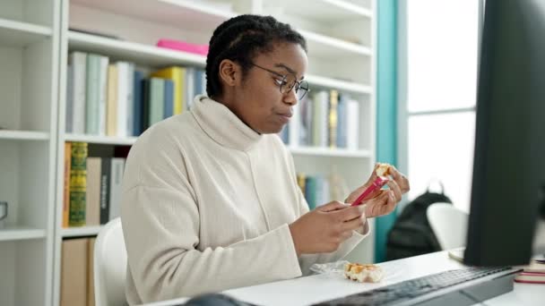 Afrykańska Amerykańska Studentka Używająca Smartfona Jedzącego Gofry Uniwersytecie Bibliotecznym — Wideo stockowe