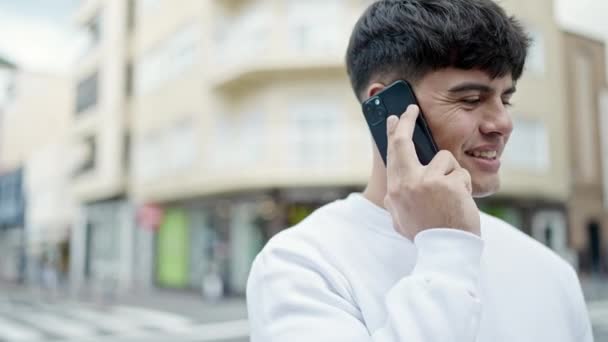 Νεαρός Ισπανόφωνος Μιλάει Στο Smartphone Χαμογελώντας Στο Δρόμο — Αρχείο Βίντεο