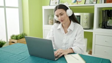 Genç, güzel, İspanyol bir kadın masada oturmuş, yemek odasında dinleniyor.