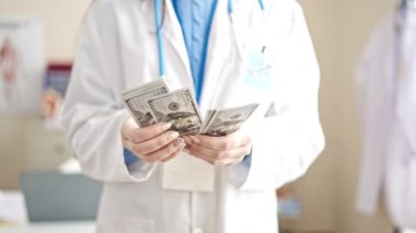 Klinikte dolar sayan beyaz kadın doktor.