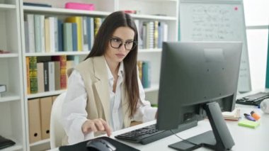 Üniversite sınıfında bilgisayar kullanan güzel İspanyol bir kız öğrenci.