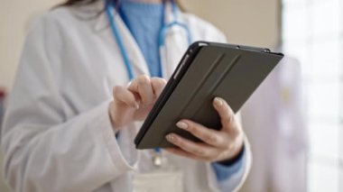 Genç beyaz kadın doktor klinikte dokunmatik ped kullanıyor.