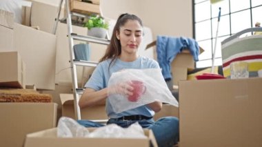 Genç, güzel İspanyol kadın yeni evinde karton kutu paketliyor.