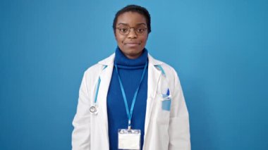 Afro-Amerikalı kadın doktor, izole edilmiş mavi arkaplanı onaylıyor.