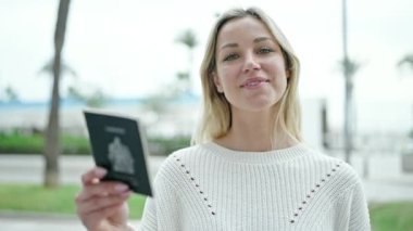 Genç sarışın kadın gülümsüyor. Kendine güvenen yeni arabanın anahtarını işaret ediyor.