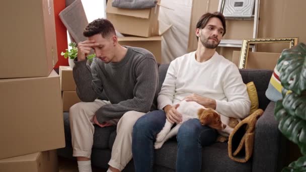 Dos Hombres Pareja Estresado Sentado Sofá Con Perro Casa Nueva — Vídeos de Stock