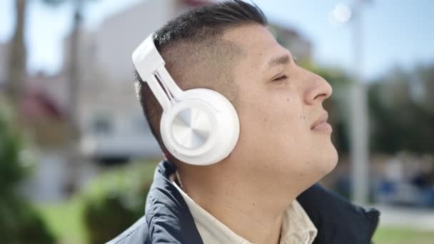 Молодой Латиноамериканец Слушает Музыку Парке — стоковое видео