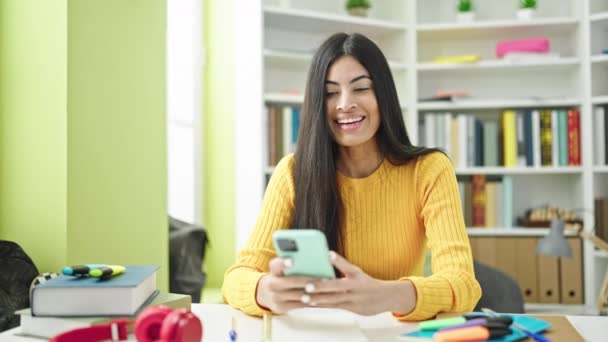 Fiatal Gyönyörű Spanyol Diák Segítségével Smartphone Tanul Győztes Kifejezés Könyvtár — Stock videók