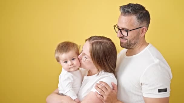 Familie Van Moeder Vader Baby Zoenen Geïsoleerde Gele Achtergrond — Stockvideo