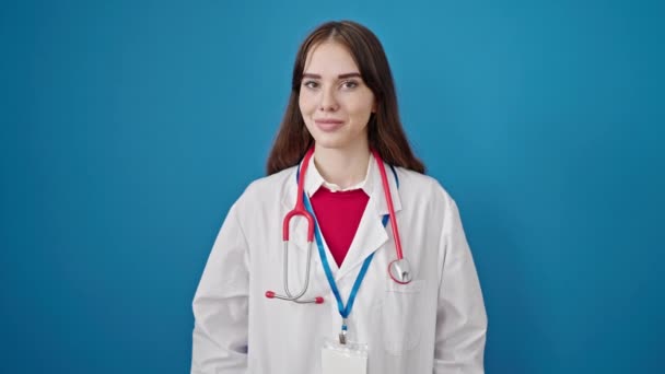 Νεαρή Ισπανίδα Γιατρός Χαμογελά Σίγουρος Στέκεται Πάνω Από Απομονωμένο Μπλε — Αρχείο Βίντεο