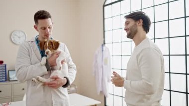 Veteriner kliniğinde el sıkışan iki adam.