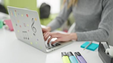 Kütüphane üniversitesinde okuyan genç, beyaz bir kız öğrenci dizüstü bilgisayar ve dokunmatik ped kullanıyor.