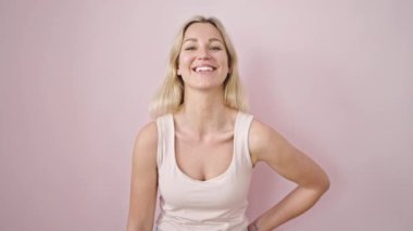 Young blonde woman smiling confident standing over isolated pink background