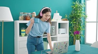 Genç, güzel İspanyol kadın yemek salonunda müzik dinliyor ve dans ediyor.