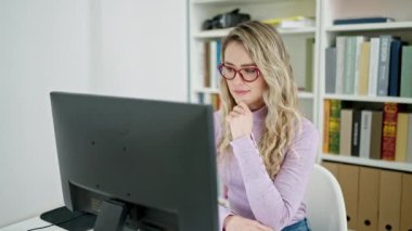 Sınıfta bilgisayar kullanan genç sarışın kız öğrenci.