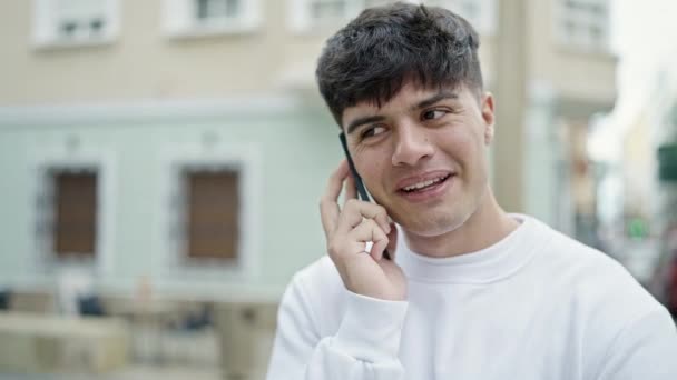 Νεαρός Ισπανόφωνος Μιλάει Στο Smartphone Χαμογελώντας Στο Δρόμο — Αρχείο Βίντεο