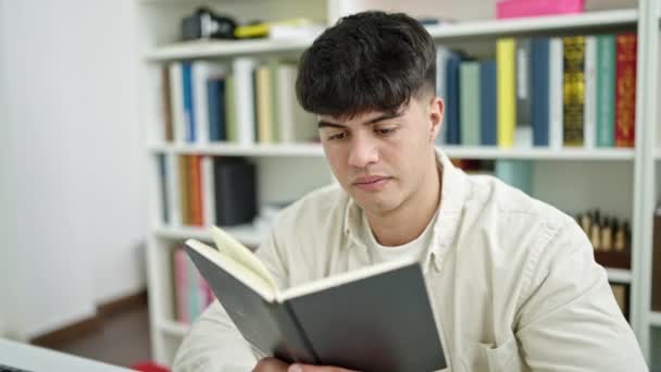 Tânăr Hispanic Student Citind Carte Așezat Masă Universitatea Bibliotecii — Videoclip de stoc