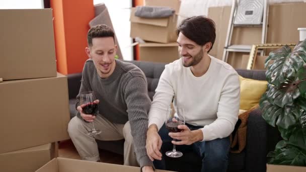 Zwei Männer Trinken Glas Wein Beim Auspacken Von Pappkartons Neuen — Stockvideo