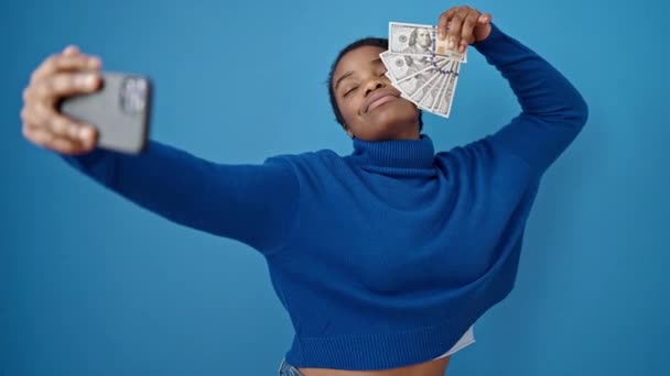 Afrikaans Amerikaanse Vrouw Nemen Selfie Holding Dollars Geïsoleerde Blauwe Achtergrond — Stockvideo