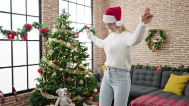 Genç sarışın kadın Noel 'i kutluyor evde dans ediyor