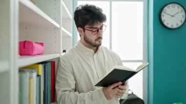Genç İspanyol öğrenci kütüphane üniversitesinde kitap okuyor.